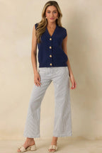 Navy blue knit sweater vest with gold shell buttons, front view