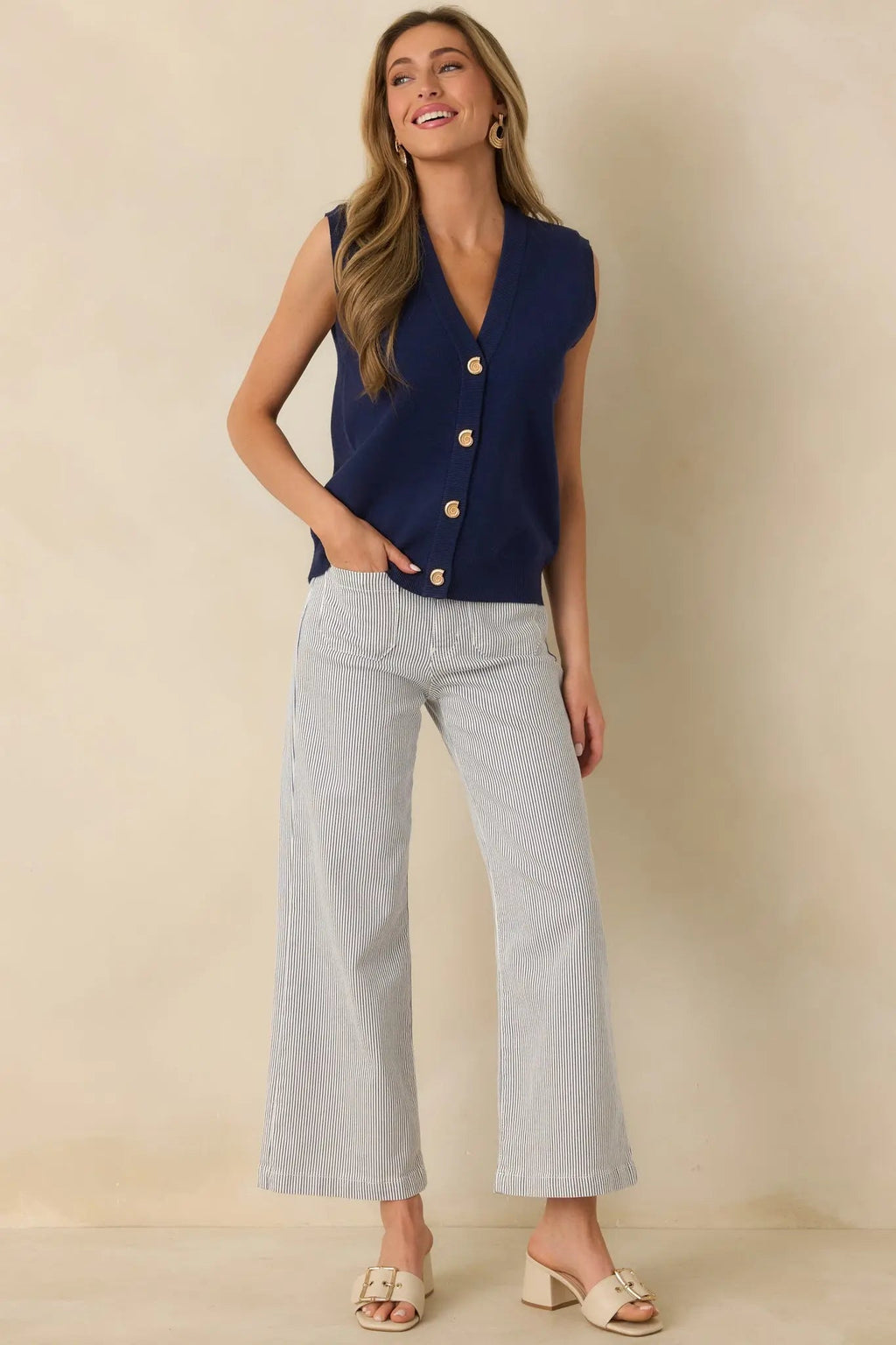 Navy blue knit sweater vest with gold shell buttons, detail view