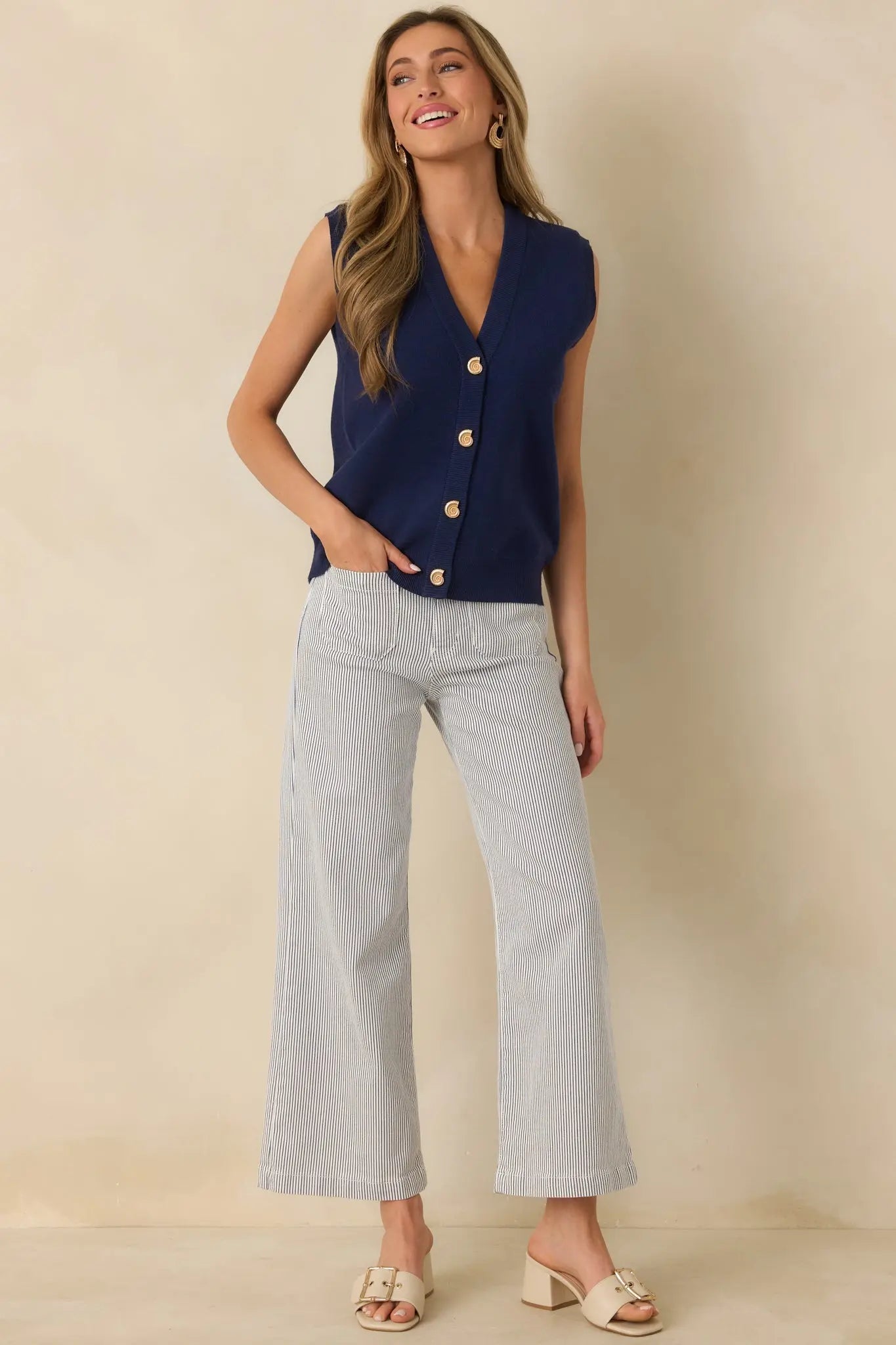 Navy blue knit sweater vest with gold shell buttons, detail view