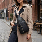 Woman wearing the black vegan-leather crossbody bag in an urban setting