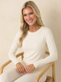 Woman wearing a cream long-sleeve shell top, lifestyle